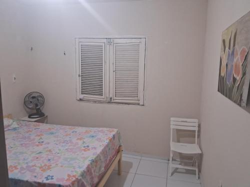 a bedroom with a bed and a window and a chair at Kasa Morro Branco in Beberibe