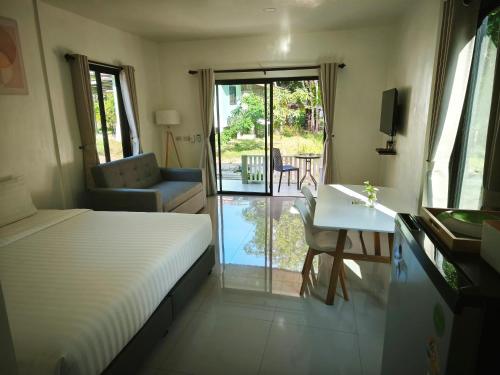 une chambre avec un lit, un bureau et une table dans l'établissement The Secret Garden Homestay Koh Yao Yai, à Ban Lo Pla Lai (1)
