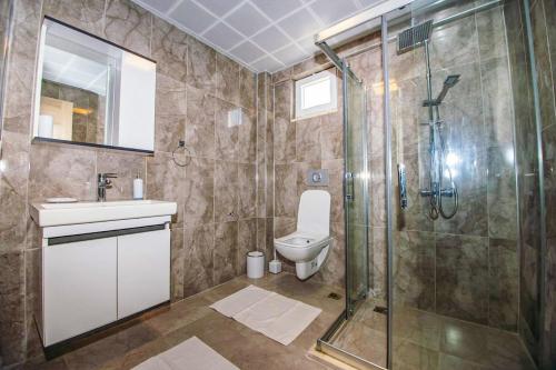 a bathroom with a shower and a toilet and a sink at Villas Dogakent in Ortaca