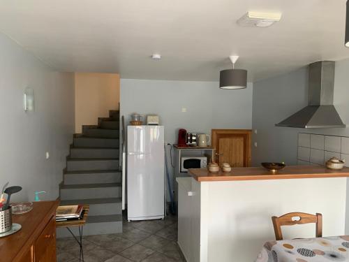 Il comprend une cuisine avec un escalier et un réfrigérateur. dans l'établissement SEJOUR AU COEUR DES VOLCANS, à Saint-Ours