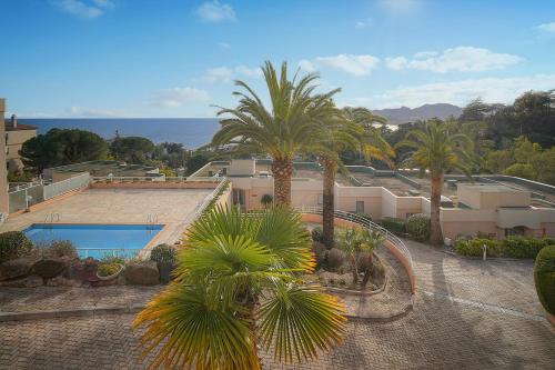 - une vue aride sur une maison avec des palmiers et une piscine dans l'établissement Auré-Parking-Piscine-Terrasse-VCA, à Cannes