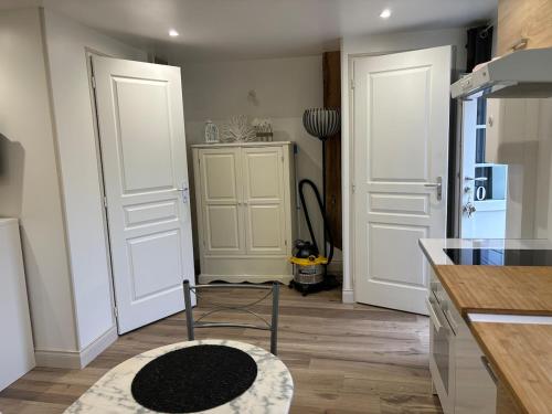une cuisine avec des portes blanches et une chaise dans une pièce dans l'établissement Studio avec cour, à Briare