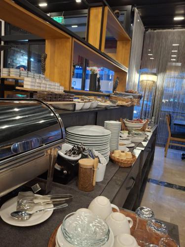 una linea a buffet con piatti e utensili in un ristorante di DEWY HOTEL a Smirne