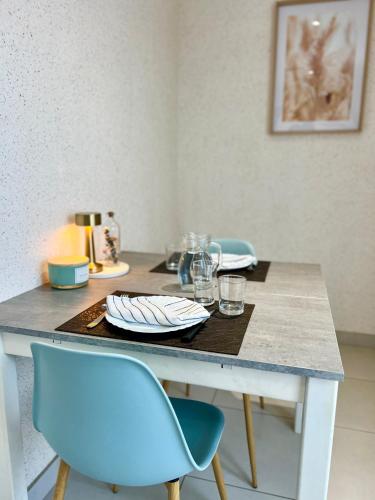 une table avec deux chaises et une table avec des assiettes et des verres dans l'établissement La Côtière, Terrasse et Jardin RDC, Proche plage, à Saint-Palais-sur-Mer