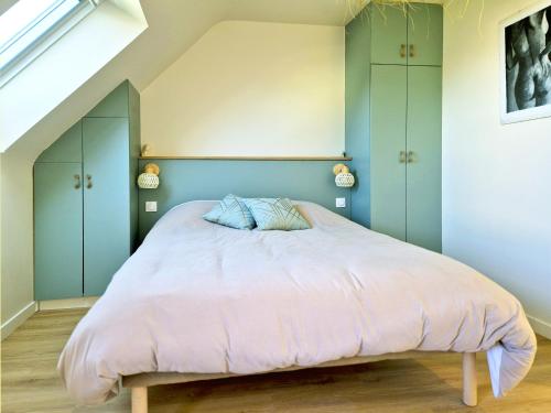 - une chambre avec un grand lit et une couette rose dans l'établissement Ty-Bod Les Gîtes de la Côte d'Amour, à Batz-sur-Mer