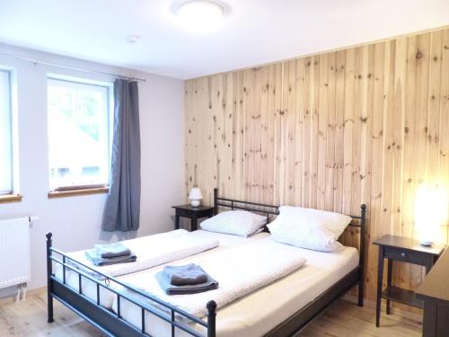 two beds in a room with a wooden wall at Ferienwohnung Sonne in Walsrode