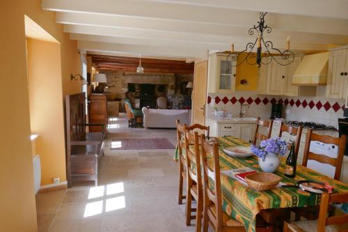 une cuisine et une salle à manger avec une table et des chaises dans l'établissement 711- Spacieuse ferme bretonne avec sauna et grand, à Beuzec-Cap-Sizun