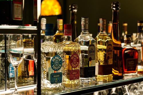 a group of bottles of alcohol on a shelf with glasses at Moselle Armenia Wellness & Medical SPA Jermuk in Jermuk