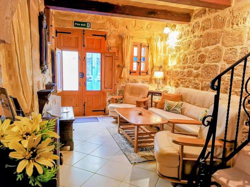 a living room with a couch and a table at Mdina Gate Retreat - A charming house of character in Rabat
