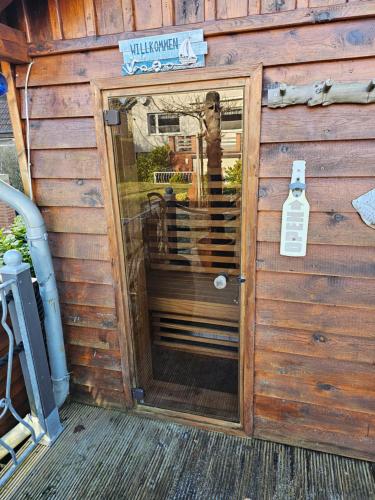 a wooden shed with a door in the middle at Kapitänshaus - Wolkenstube in Barth
