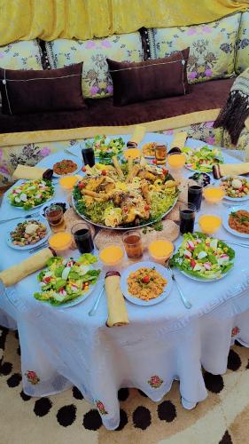 a table with plates of food on it at Dar Khmissa Fes-Luxury Stay Fes Medina in Fès