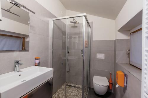 a bathroom with a shower and a toilet and a sink at StraVagante Hostel & Rooms in Verona