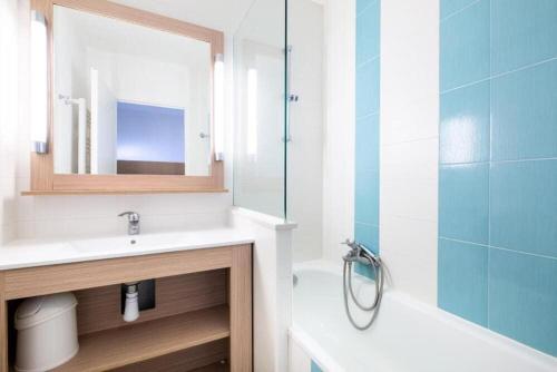 une salle de bain avec un lavabo, un miroir et une baignoire dans l'établissement Bel appartement climatisé Saint-Raphaël, à Saint-Raphaël