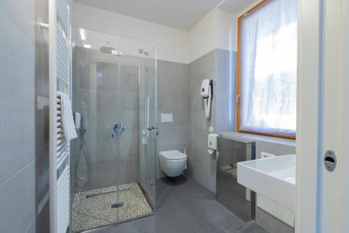 a bathroom with a shower and a toilet and a sink at StraVagante Hostel & Rooms in Verona