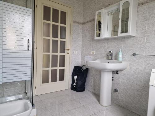 a bathroom with a sink and a shower and a mirror at Appartamento Divino Tramonto in Altedo