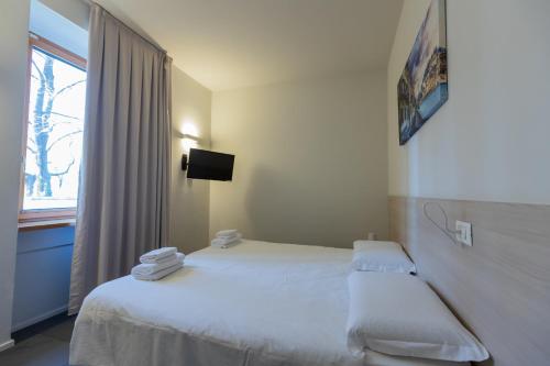 a hotel room with two beds and a window at StraVagante Hostel & Rooms in Verona
