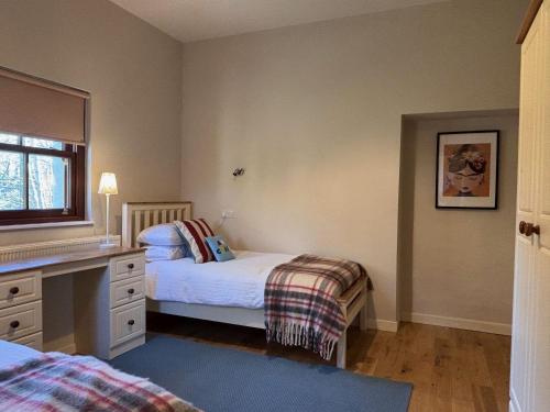 a small bedroom with two beds and a desk at Cottage 474 - Kylemore in Kylemore