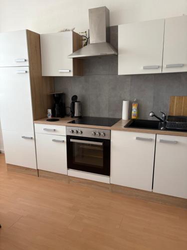 a kitchen with white cabinets and a stove top oven at Monteurwohnungen WalMel kostenloses Parken und W-LAN in Bütthard