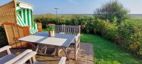 ein Tisch und Stühle auf einer Terrasse in der Unterkunft Ferienwohnung Lachmöwe in Norddorf