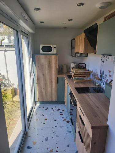 une cuisine avec un comptoir et une grande fenêtre dans l'établissement La petite maison blanche, à Dunkerque