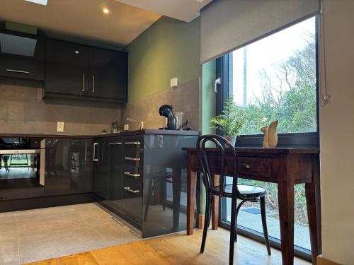 a kitchen with black cabinets and a wooden table at Cottage 475 - Kylemore in Kylemore