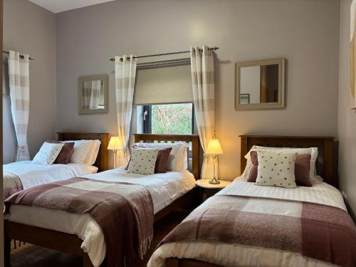 a bedroom with two beds and a window at Cottage 475 - Kylemore in Kylemore