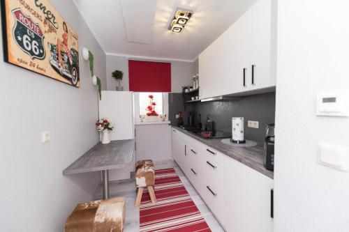 a small kitchen with white cabinets and a rug at Ferienappartment Brigitte Güterglück in Güterglück