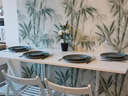 a table with plates and glasses and flowers on it at Gare Montparnasse,gorgeous1 bedroom,close to Eiffel tour,center , stuning place in Paris
