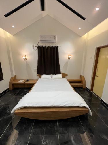 a bedroom with a large bed with a black curtain at Amrapali Resort in Top