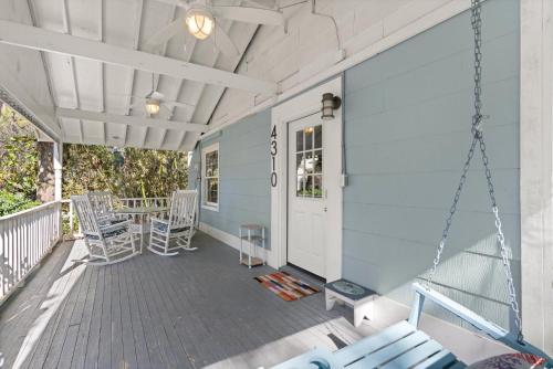 a porch with rocking chairs and a swing at Sunshine Daydreams - 4310 Seventh Street in Saint Simons Island