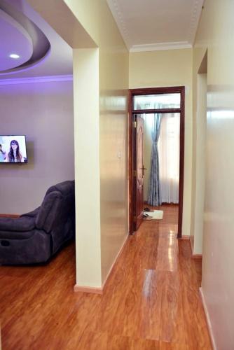 a living room with a couch and wooden floors at Plush Serene home next to Thika Greens Golf Estate in Thika