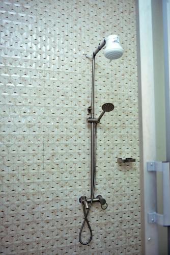 a shower in a bathroom with a light on the wall at Plush Serene home next to Thika Greens Golf Estate in Thika