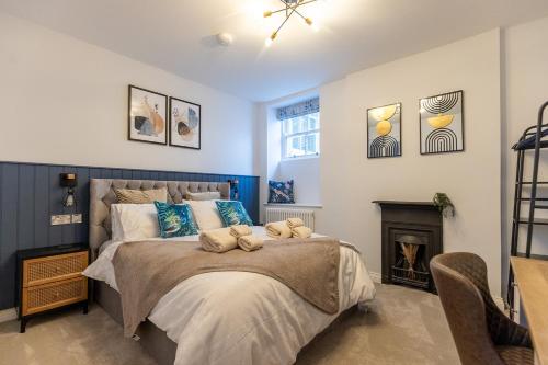 a bedroom with a large bed and a fireplace at The York House Luxury Apartment located in Llandudno in Llandudno