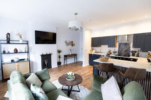 a living room and kitchen with a couch and a table at The York House Luxury Apartment located in Llandudno in Llandudno