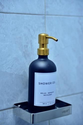 a bottle of shower gel sitting on a shelf at Plush Serene home next to Thika Greens Golf Estate in Thika