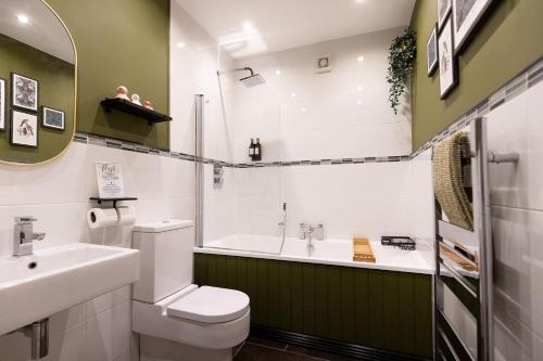 a bathroom with a sink and a toilet and a tub at The York House Luxury Apartment located in Llandudno in Llandudno