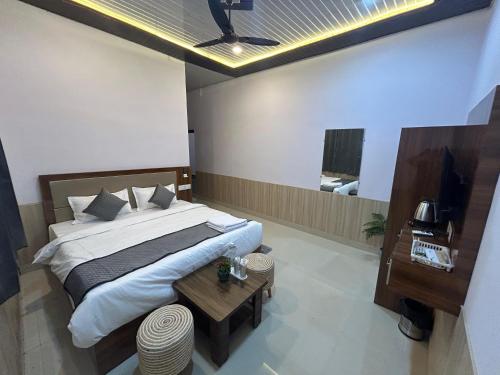 une chambre avec un grand lit et une table dans l'établissement Blackberry Resort Pushkar - Nature with Pool, à Pushkar