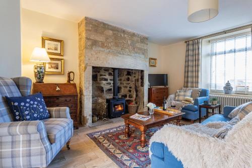 a living room with two couches and a fireplace at Puddler's Cottage in Bedlington
