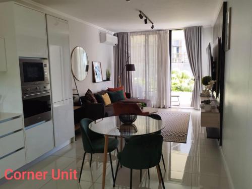 a living room with a table and a couch at Stylish Modern 2BR in Waterfall Ellipse - Sleeps 4 - Fast WiFi - Secure Parking in Midrand