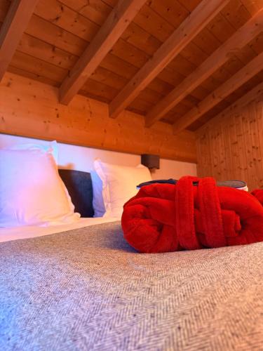 a red stuffed animal is laying on a bed at Hotel Bel'alpe in Morzine