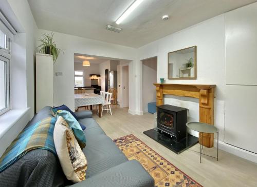 a living room with a blue couch and a fireplace at Cottage 483 - Renvyle in Letterfrack