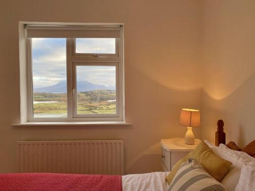 a bedroom with a window with a bed and a lamp at Cottage 483 - Renvyle in Letterfrack