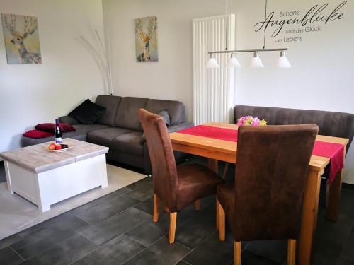 a living room with a table and a couch at Auszeithof Otersen - Ferienwohnung 4 in Kirchlinteln