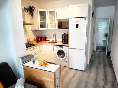 a kitchen with a white refrigerator and a washing machine at Orion's Moon in Las Eras