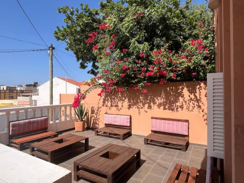 a group of benches sitting on a balcony with flowers at Vila Mira Mar in Mindelo