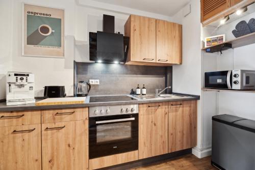 a kitchen with wooden cabinets and a sink at CozyHome Hauptmarkt Apartments in Gotha