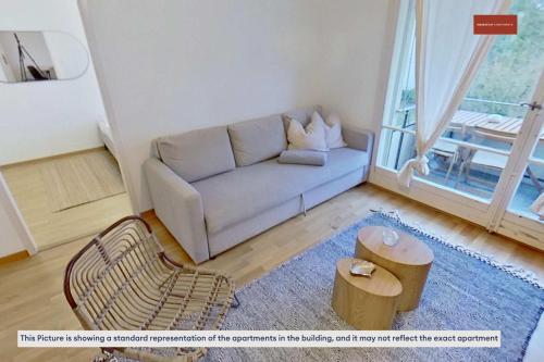 a living room with a couch and a table at Basic 2BR with Natural Light in Zürich