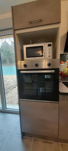 a microwave sitting on top of an oven at Maison neuve 14km beauval jardin wifi PMR in Valençay