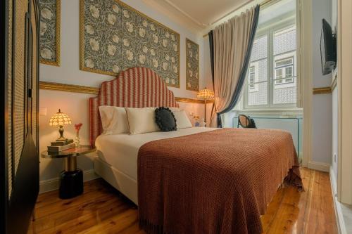 a bedroom with a bed with a red and white blanket at Solar dos Poetas in Lisbon