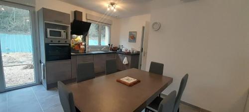 a kitchen with a wooden table and a dining room at Maison neuve 14km beauval jardin wifi PMR in Valençay